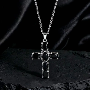 Dettaglio della collana a croce gotica in argento con pietre nere su seta scura