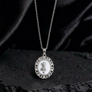 Primer plano del collar con colgante de girasol, nácar blanco y circonitas brillantes