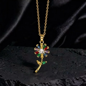Detalle del collar con colgante de flor dorada y cristales de colores en piedra oscura