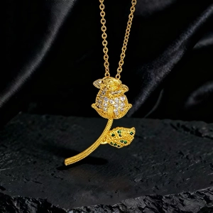 Detalle del collar con colgante de rosa con circonitas blancas y gema verde sobre seda
