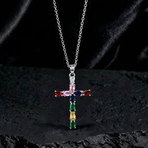 Dettaglio del ciondolo a croce in argento con pietre preziose colorate su roccia nera