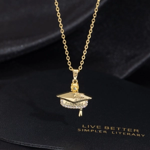 Golden graduation cap necklace with custom name and yellow gemstone on black silk