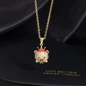 Collar de oso con corona dorada y circonitas blancas sobre fondo de seda negra
