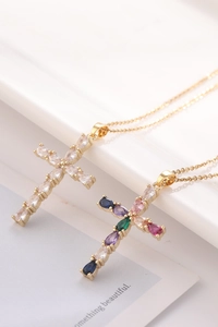 Detailed shot of gold plated cross necklaces with colorful pear-cut cubic zirconia crystals