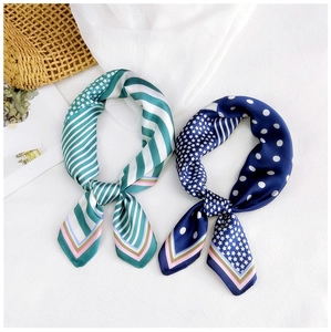 Détail de petits carrés de soie élégants avec rayures vertes et motifs à pois bleus