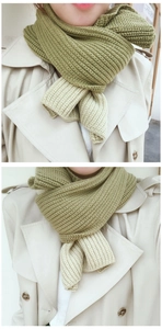 Detail of green and beige bicolor knitted scarf with vertical stripe texture