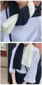 Close-up of two-tone knitted scarf showing thick texture and chunky knit pattern