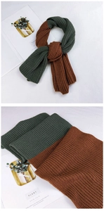 Detailed close-up of thick rib-knit texture and two-tone stitching on the long winter scarf