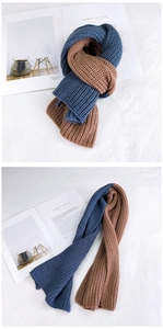 Detail of blue and caramel chunky knit scarf showing thick weave texture and soft material