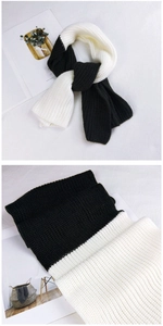 Detailed close-up of thick knit texture on black and white two-tone winter scarf