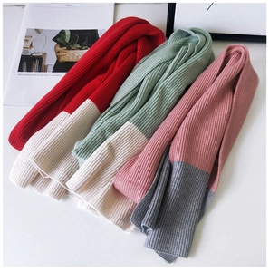 Detail of ribbed knit scarves in red-white, green-white, and pink-gray color combinations