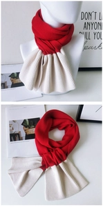 Detail of red and cream two-tone ribbed knit scarf featuring a convenient cross-slot design