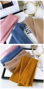 Detailed view of ribbed knit arm warmers in pink, blue, khaki and yellow soft fabric