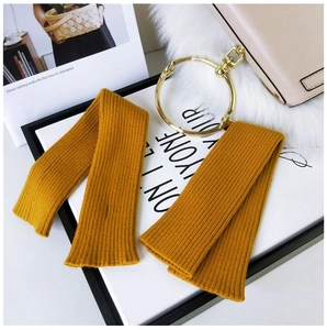 Detail of ginger yellow knitted arm sleeves with minimalist vertical ribbed texture