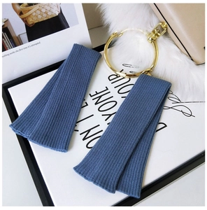 Detailed view of blue knitted arm warmers with vertical ribbed texture on display
