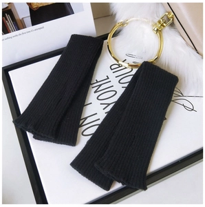 Detail of black ribbed knit arm warmers with thumb holes on a stylish lifestyle background