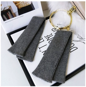 Close-up of dark grey knitted arm warmers with vertical ribbed texture and soft finish