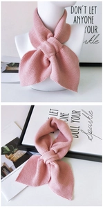 Detailed knit texture of pink winter scarf with a criss-cross fastening loop design