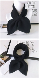 Close-up of black knitted scarf featuring a unique cross-bow design and thick texture