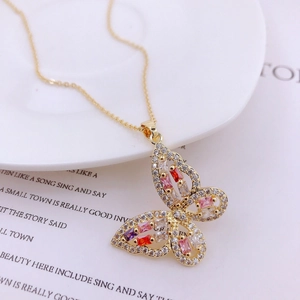 Detail of gold butterfly pendant with colorful zircons and micro-pave crystals on chain