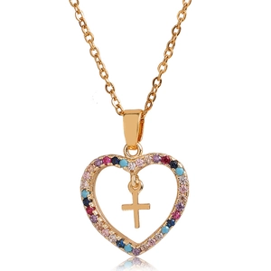 Collier cœur doré avec pavé de zircons colorés et pendentif croix sur fond blanc épuré