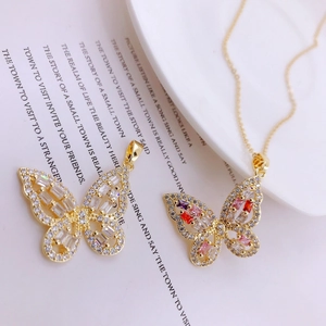 Close-up of butterfly pendant necklace with colorful zircon stones on vintage paper