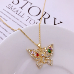 Detail of butterfly necklace pendant with colorful gemstones and white crystals on gold chain