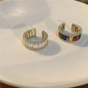 Detail view of gold-plated ear cuffs set with colorful zircon and rectangular crystals