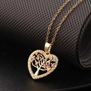 Collier cœur arbre de vie plaqué or avec zircons colorés sur texture foncée