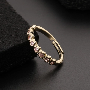 Macro shot of gold adjustable ring with pink star-shaped cubic zirconia stones