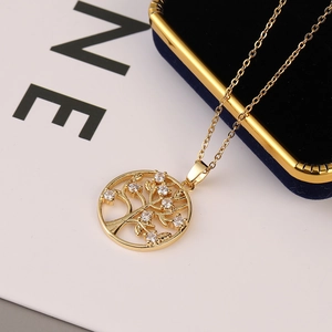 Golden Tree of Life necklace with cubic zirconia stones on blue velvet box