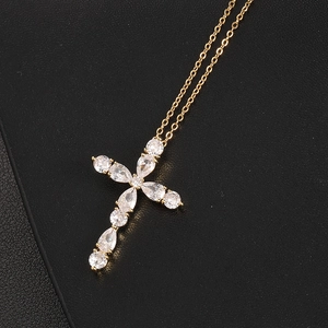 Cross pendant necklace with colorful zircon stones on gold chain over black leather