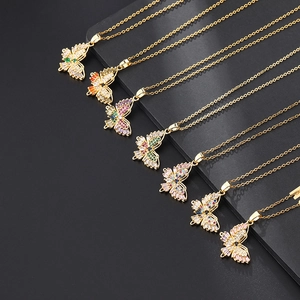 Gros plan de colliers papillon dorés sertis de zircons colorés aux teintes variées