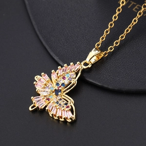 Gros plan du pendentif papillon doré orné de zircons colorés sur support en cuir