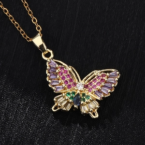 Vue macro du pendentif papillon en zircons colorés et plaqué or sur fond noir