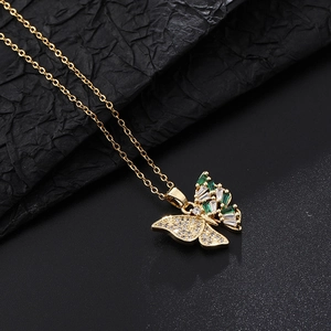 Détail macro du pendentif papillon avec zircons verts et cristaux blancs brillants