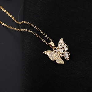 Vue macro du pendentif papillon doré avec pierres en zircone sur fond en tissu noir