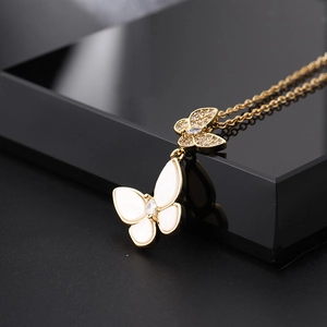 Détail du collier double papillon en nacre avec incrustations de zircons et chaîne dorée