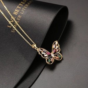 Gros plan du pendentif papillon doré avec des zircons multicolores de taille baguette