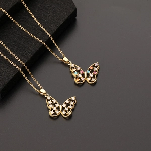 Gros plan de pendentifs papillon avec zircons colorés et chaîne plaquée or élégante