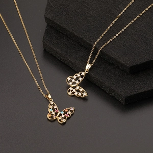 Gros plan de pendentifs papillons dorés avec oxydes de zirconium colorés et blancs