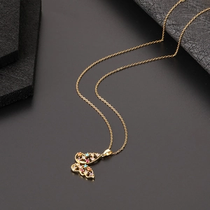 Détail d'un pendentif papillon doré avec oxydes de zirconium colorés sertis