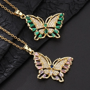 Vue macro d'un pendentif papillon coloré avec zircons sur fond de texture noire