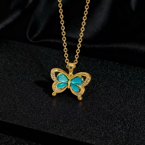 Vue macro du pendentif papillon doré avec ailes bleu ciel et détails en zircone micro