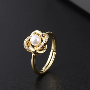 Macro detail van een gouden verstelbare ring met witte parel en fonkelende steentjes