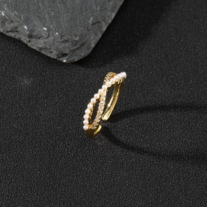 Macro detail of gold-plated double-layer ring with white pearls and sparkling crystals