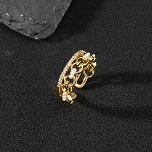 Detail of adjustable gold ring with pavé zircons and delicate white pearls chain