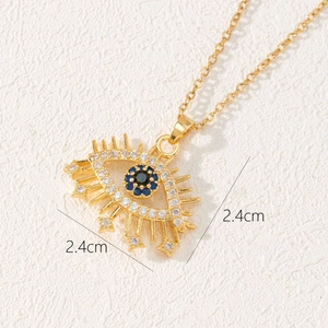 Detail view of gold evil eye pendant showing 2.4cm size and zircon star accents