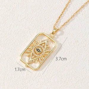 Detail shot of gold evil eye rectangular pendant showing dimensions 3.7cm by 1.7cm