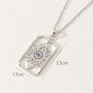Detailed macro view of silver rectangle evil eye pendant with blue and white zircons